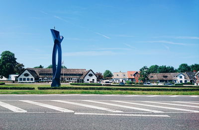 Road by buildings against sky in city