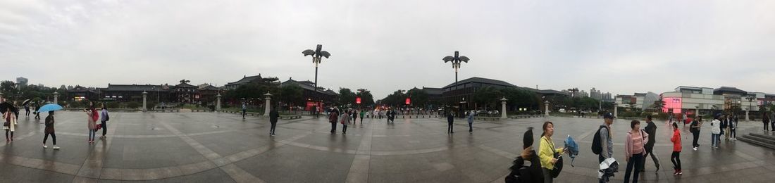 People on street in city against sky