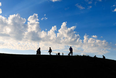 Silhouette people standing on land against sky