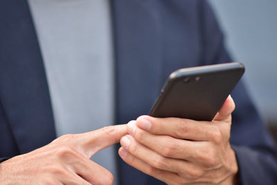 Midsection of man using mobile phone