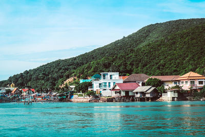 Scenic view of sea and houses against sky