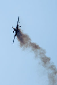 Low angle view of airplane flying against clear blue sky