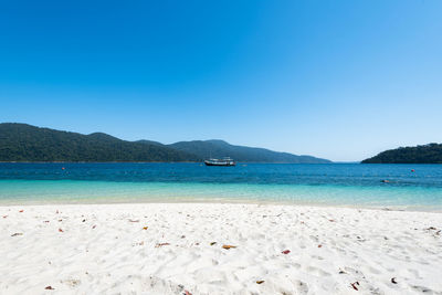 Scenic view of sea against clear blue sky