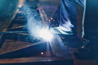 Low section of man working on metal at night