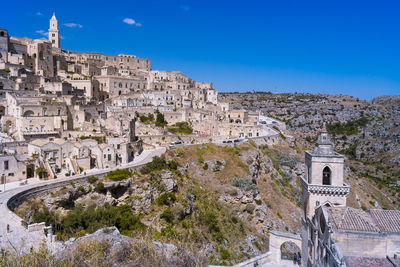 Buildings in city against clear blue sky