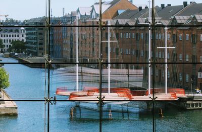 Boats moored in canal by buildings in city