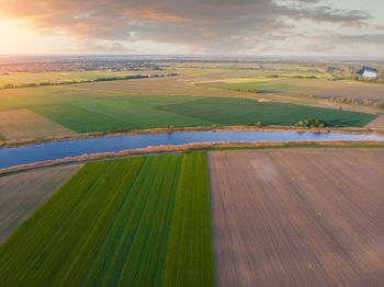 Scenic view of agricultural field against sky during sunset