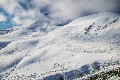 Scenic view of snow covered mountains against sky