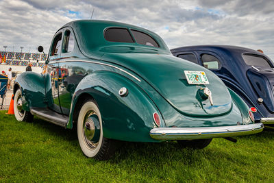 Vintage car parked on land against sky