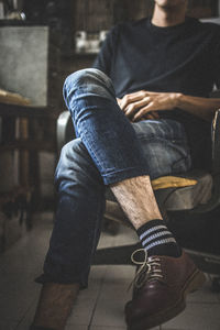 Low section of man sitting on seat