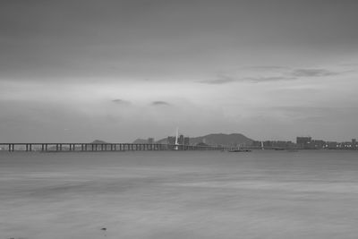 Built structure in water against cloudy sky