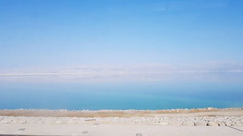 Scenic view of beach against blue sky