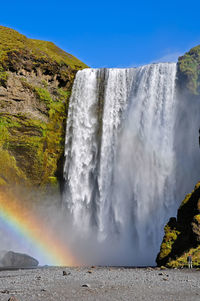 Scenic view of waterfall against sky