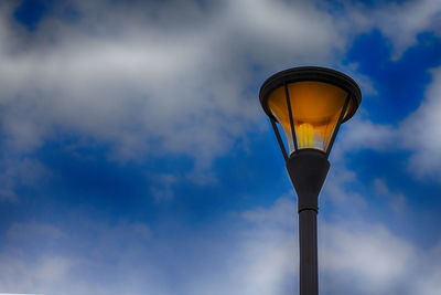 Low angle view of illuminated street light against sky