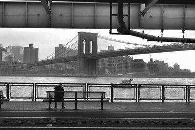 Low angle view of brooklyn bridge over river in city