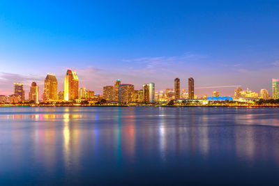 Illuminated buildings in city at waterfront