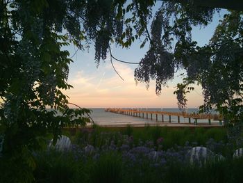 Scenic view of river against sky at sunset
