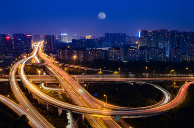 High angle view of illuminated road against built structures