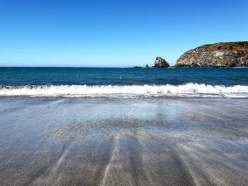 Scenic view of sea against clear blue sky