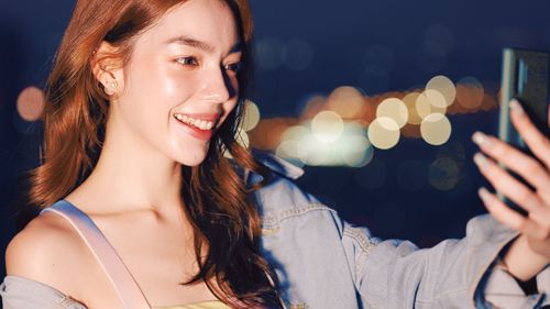 Portrait of smiling young woman at night