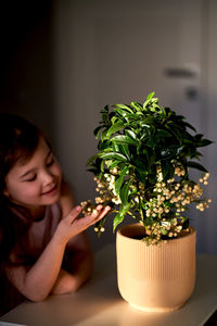 Portrait of young woman holding plant