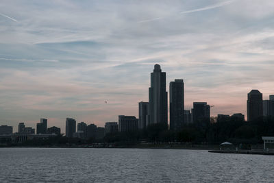 Modern cityscape against sky during sunset