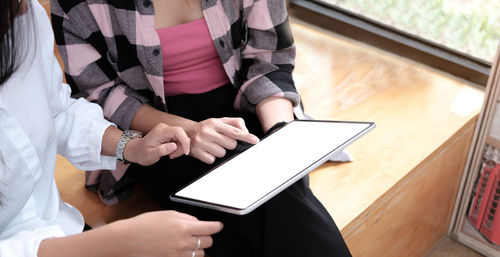 Midsection of woman using mobile phone