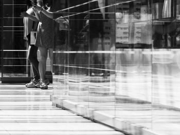 Low section of woman walking on glass window