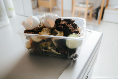 Organic waste in a small plastic box on table