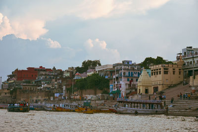 Buildings by sea against sky in city