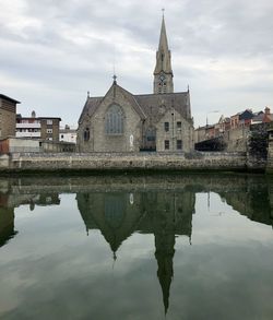 Reflection of building on water against sky