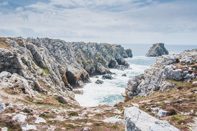 Scenic view of rocks in sea against sky