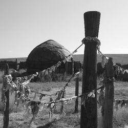 Wooden posts on field against clear sky