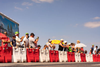 Rear view of people standing against sky