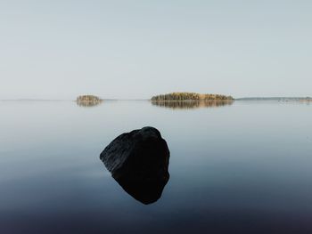 Scenic view of rocks in lake against clear sky