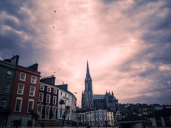 Low angle view of buildings against cloudy sky