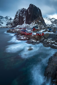 Scenic view of snowcapped mountains by sea against sky