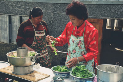 High angle view of people eating food in kitchen