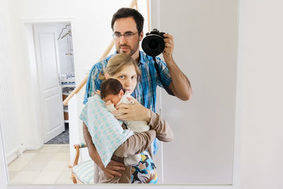 Rear view of mother with daughter standing at home