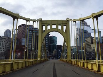 View of city street against cloudy sky