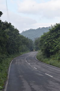 Road amidst trees against sky