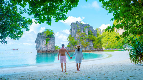 Rear view of woman standing at beach