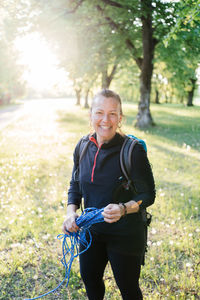 Portrait of a smiling young woman holding a rope. 