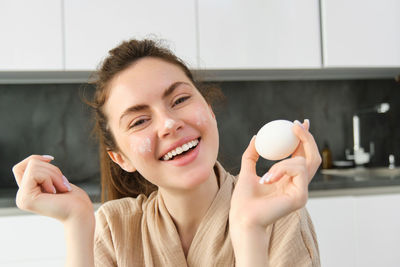 Portrait of young woman using mobile phone at home