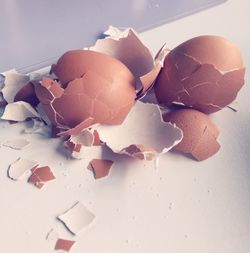 High angle view of cracked brown eggshell on table