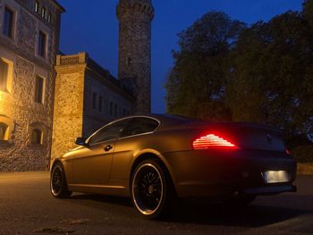 Car on street against buildings in city at night