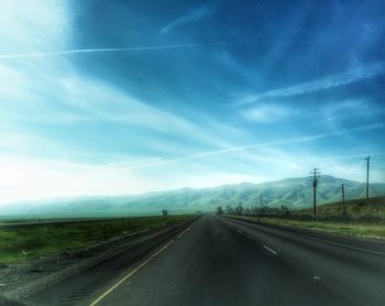 Country road against cloudy sky