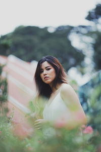 Portrait of woman standing against blurred background