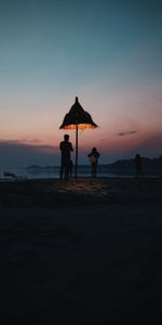 Silhouette people on beach against sky during sunset