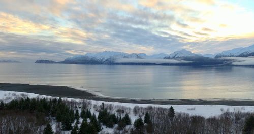 Scenic view of lake and mountains against sky during sunset